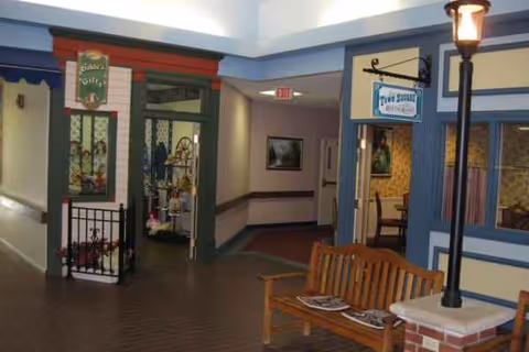 Interior hallway of Hawthorne Inn with a bench, doors, and warm decor.
