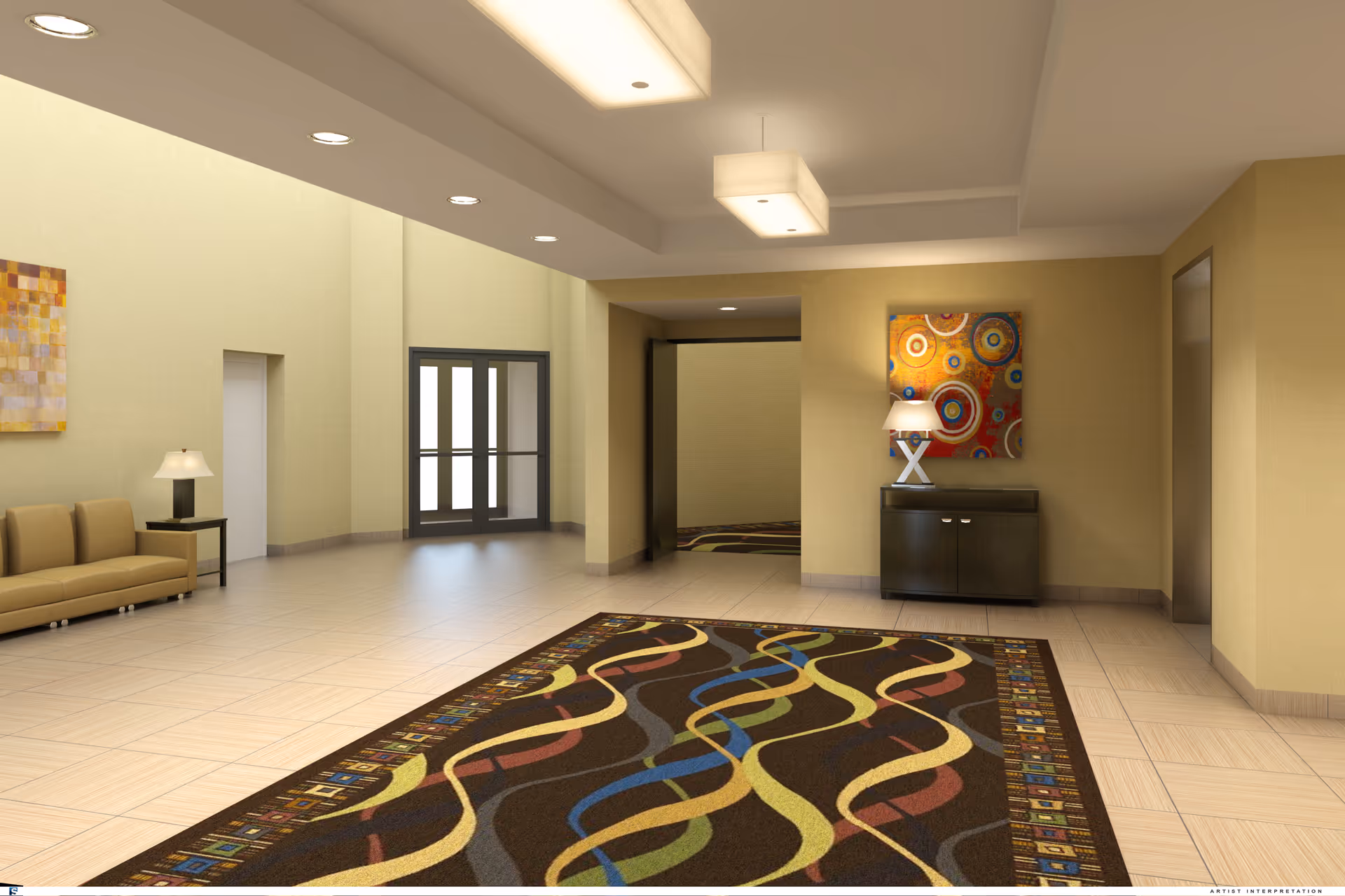 A spacious and well-lit lobby area with beige walls and tiled floors. There is a colorful patterned rug on the floor, a beige couch with a side table and lamp on the left, and a dark cabinet with a lamp and abstract circular artwork on the right. The ceiling has recessed lighting and a rectangular hanging light fixture. Double glass doors are visible at the far end of the room.