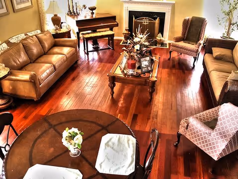 Cozy New Horizons ALF living room with leather sofas, a fireplace, and polished wood floors.