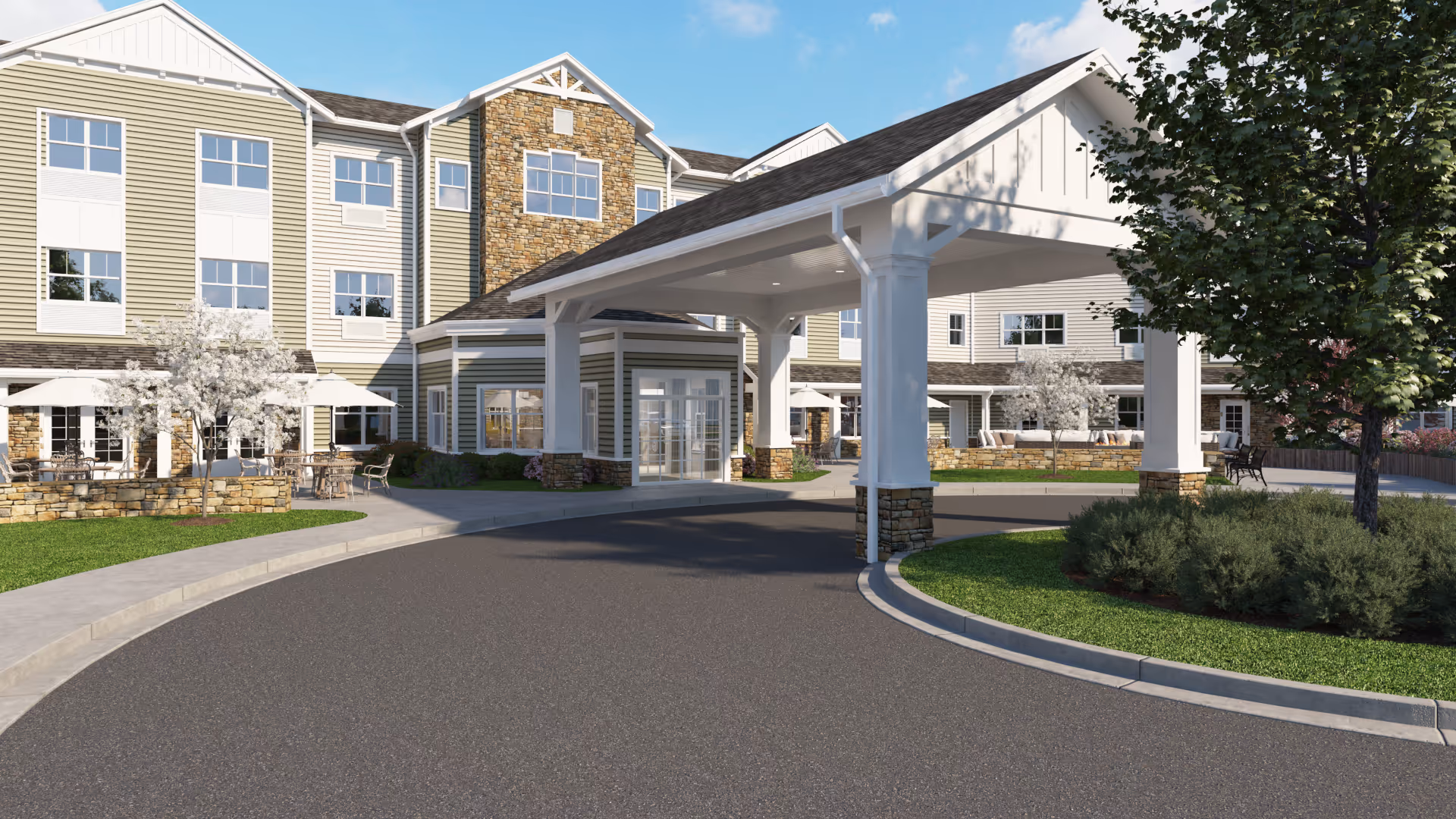 Entrance of a multi-story senior living building with a covered porte-cochere, landscaped driveway, and outdoor seating.