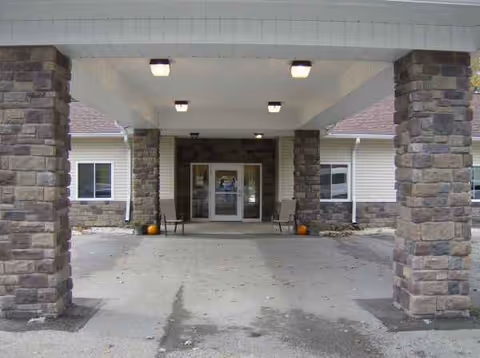 Front entrance of Eagle Pointe Skilled Nursing & Rehab Center with stone columns and covered driveway.