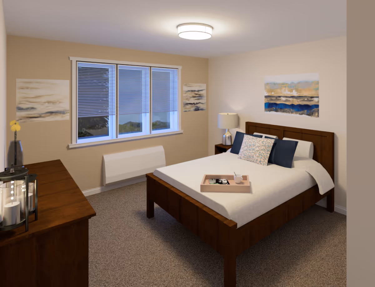 A cozy bedroom with a wooden bed frame and white bedding, decorated with three pillows including one patterned pillow. A wooden dresser with candles and a vase with a yellow flower is on the left side. There are three windows with blinds partially closed, and three abstract paintings on the beige walls. A bedside table with a lamp is next to the bed. A tray with a cup and a magazine is placed on the bed.