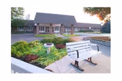 Front exterior view of Greencroft Health Care with a landscaped courtyard and bench.