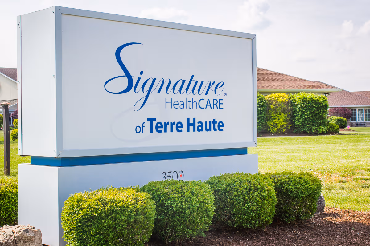 Outdoor sign reading 'Signature HealthCARE of Terre Haute' on a lawn in front of the facility.