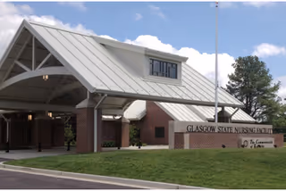 Front view of Glasgow State Nursing Facility entrance with brick exterior and covered drop-off area.