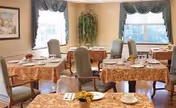 Dining room with multiple tables, chairs, and place settings.
