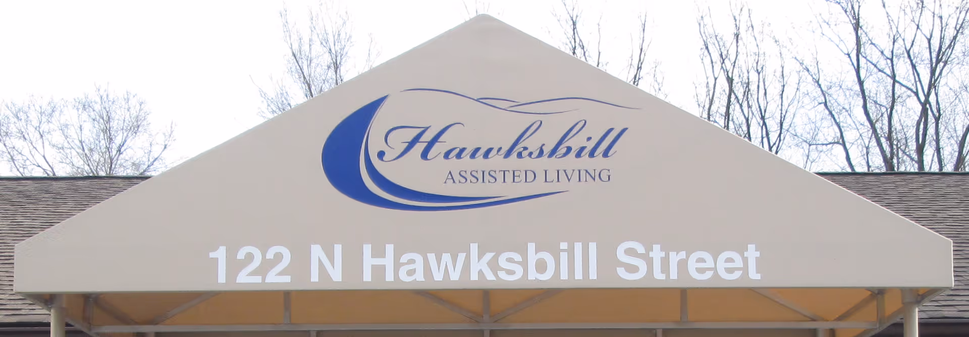 Front view of a Hawksbill Assisted Living sign with address 122 N Hawksbill Street