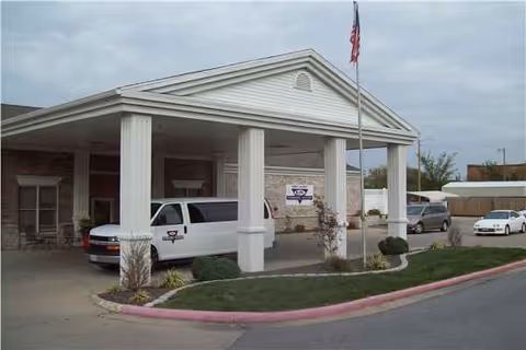 Exterior view of Parkside Manor with a covered entrance and flagpole.