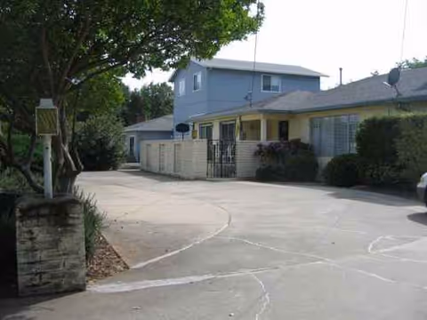 Exterior view of a light blue Spring Hills Assisted Living building with a curved driveway.