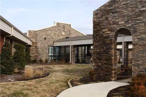 Exterior view of Crowley Ridge Care Center with stone walls and an arched entrance.