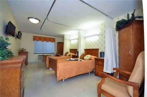 Two single beds with matching wooden furniture in a cozy hospital-style bedroom.