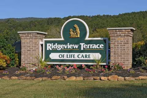 Outdoor sign for Ridgeview Terrace of Life Care with brick pillars and flowers.