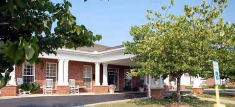 Brick exterior of Brookdale Greeneville facility with entrance, columns, and trees.