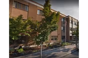 Exterior view of Maple Leaf HealthCare Center with trees along the sidewalk.