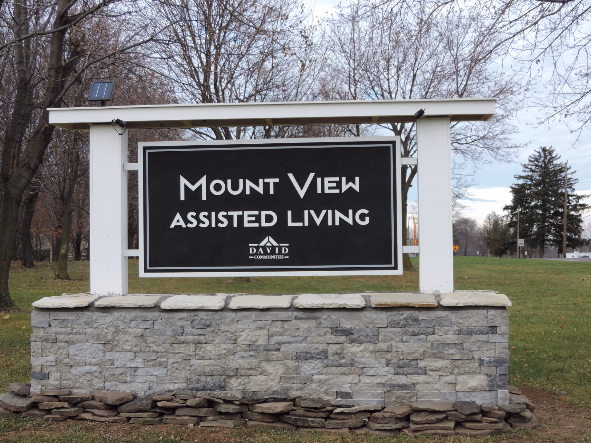 A freestanding stone-and-wood entrance sign on a lawn that reads "Mount View Assisted Living."