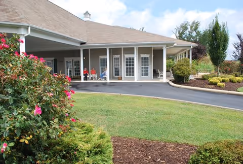 Front view of Morning Pointe of Russell with a covered entrance and residents near the doors.