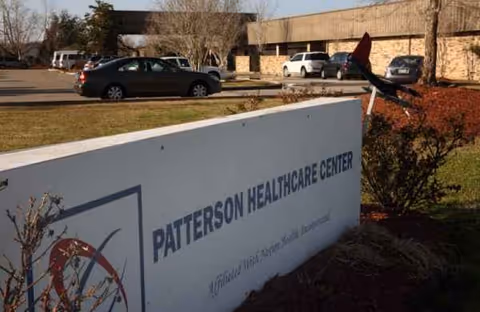 Exterior view of Patterson Healthcare Center with parking lot and signage.