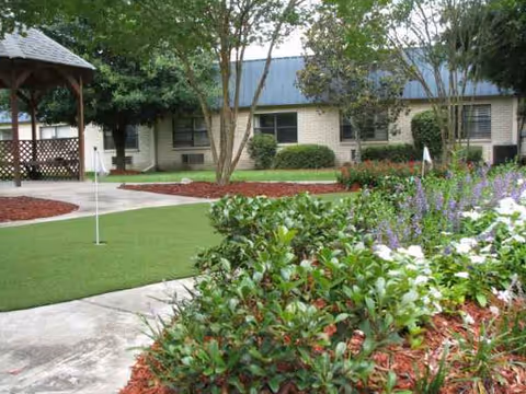Exterior view of Baton Rouge Health Care Center with a landscaped garden and gazebo.
