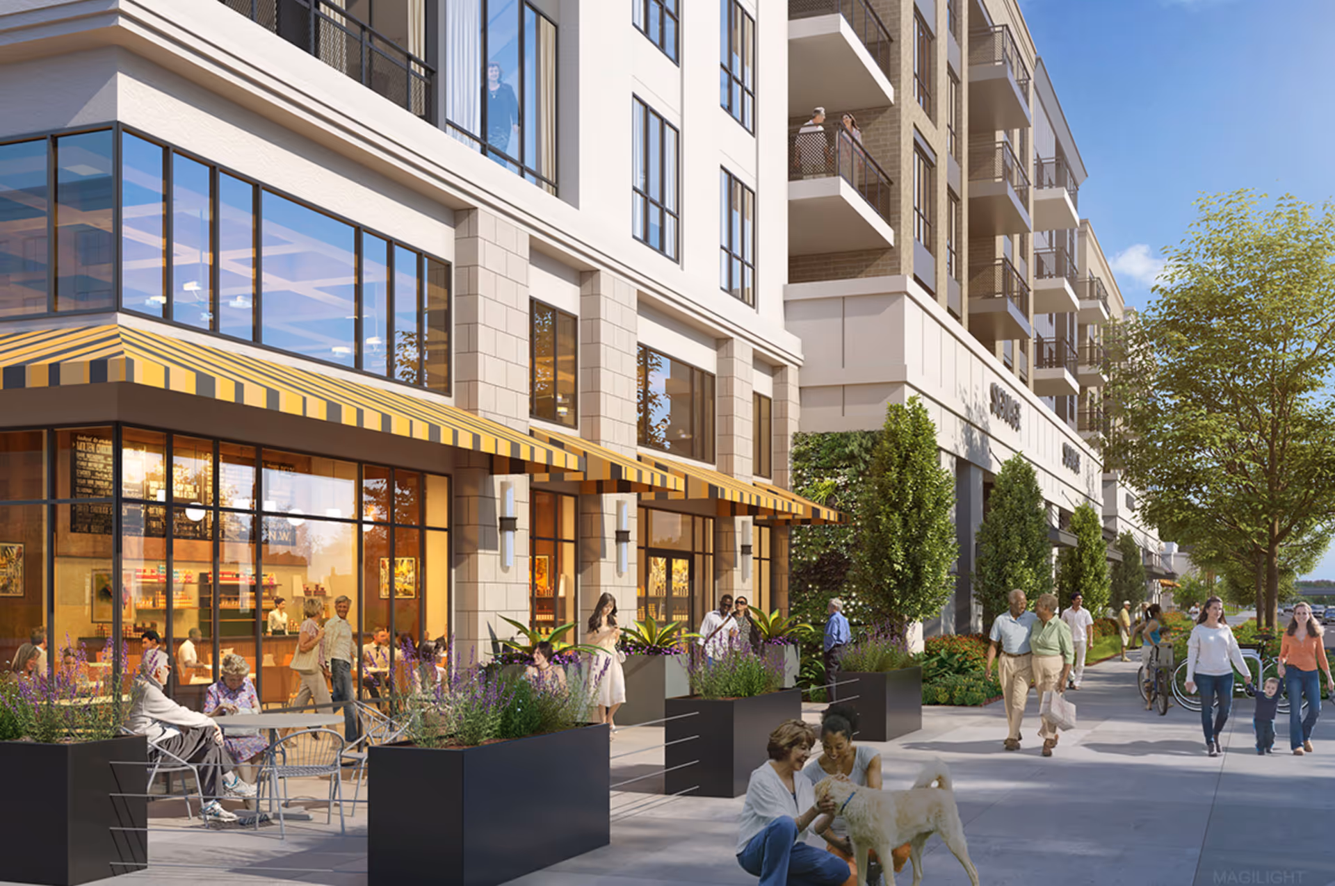 Outdoor sidewalk scene in front of a modern multi-story building with large windows and yellow-striped awnings. People are walking, sitting at outdoor tables, and interacting, including two women playing with a dog. Trees and planters line the walkway under a clear blue sky.