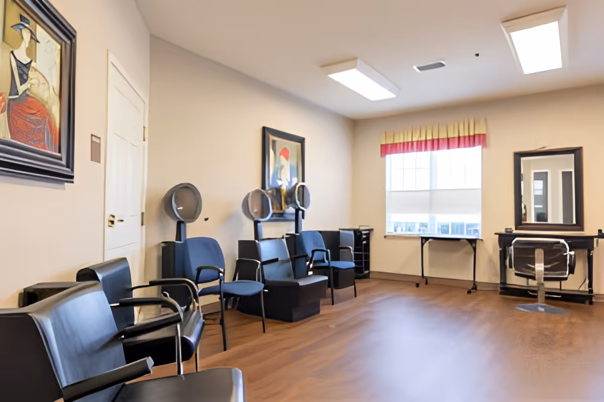 A bright salon room with multiple styling chairs, hooded hair dryers, mirrors, and a window.