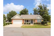 Single-story senior living facility with brick facade, front yard, and two-car garage.
