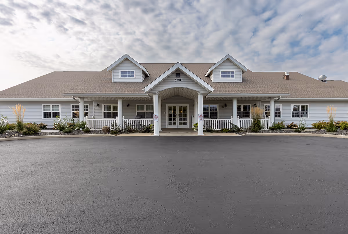 Wide view of Avista Senior Living Yakima entrance with a covered porch and landscaping.