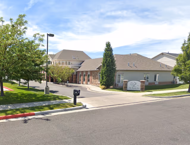 Exterior view of Family Tree Assisted Living of West Point building with a driveway, green trees, and a sign displaying the facility's name near the entrance.