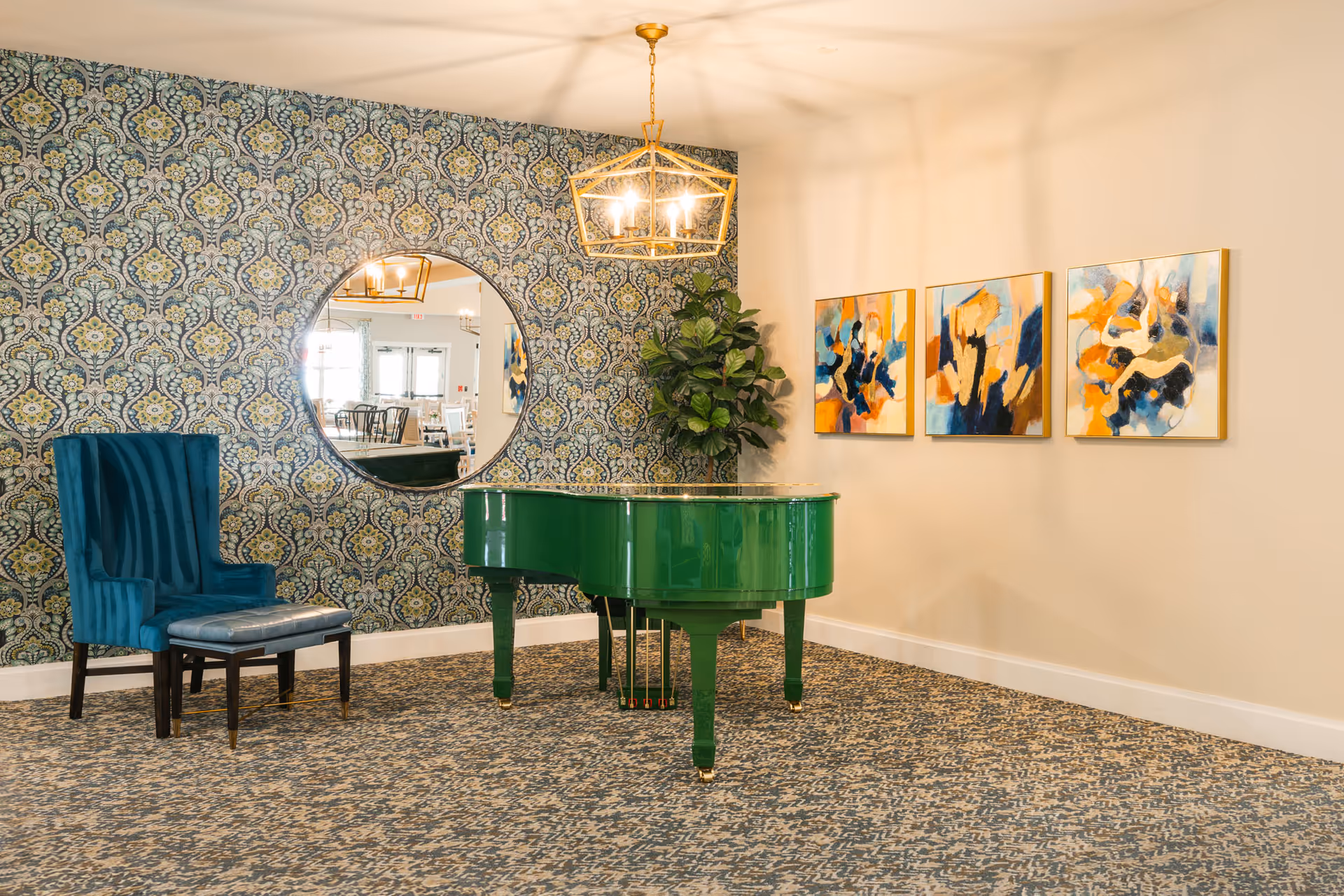 Bright lounge area with a green grand piano, teal chair, patterned wallpaper, round mirror, and abstract paintings on the wall.