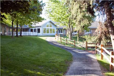 Curved path through lush lawn leads to the Georgetown & Cambridge Assisted Living entrance.
