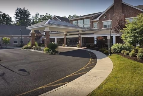Brick senior living facility with a covered entrance and curved driveway.
