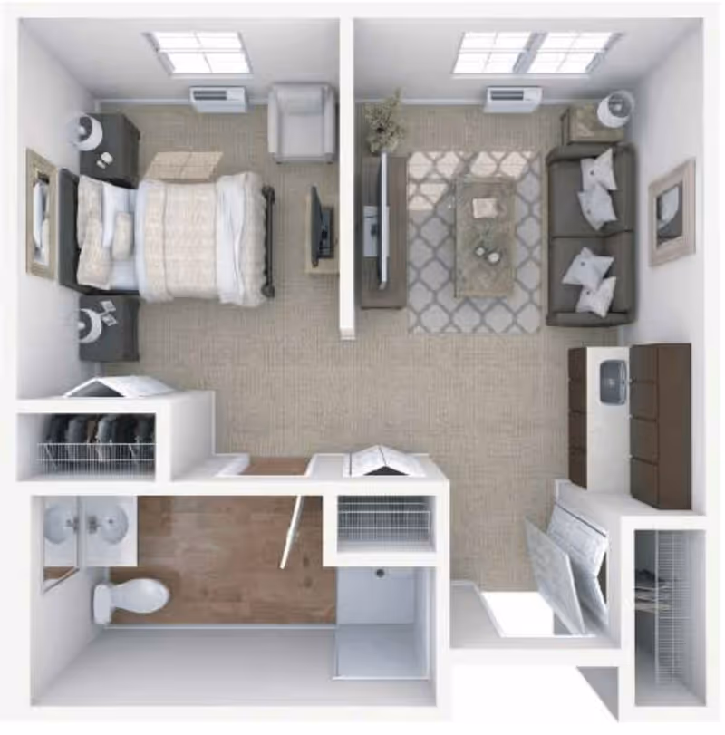 Top-down view of a senior living apartment floor plan showing a bedroom with a bed, nightstands, and an armchair; a living room with a sofa, coffee table, TV, and cabinet; a bathroom with a toilet, double sink, and shower; and closets near the entrance.