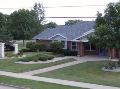 Exterior view of Elijah's Place senior living facility with landscaped grounds and a front entrance.