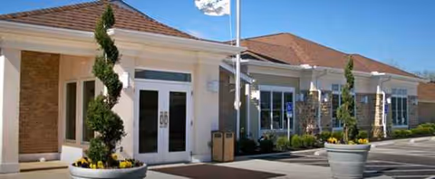 Front exterior of The Laurels of Hilliard showing entrance, planters, and parking area.