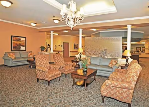 Welcoming senior living lounge with sofas, armchairs, coffee tables, and chandeliers.
