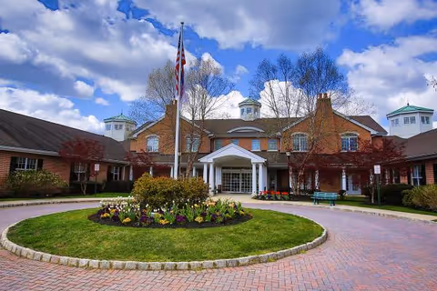 Exterior view of Brandywine Colts Neck by Monarch with circular driveway and landscaped center.