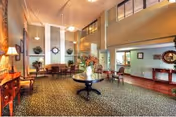Spacious senior living lobby with high ceilings, seating areas, a fireplace, and a round table topped with a floral arrangement.