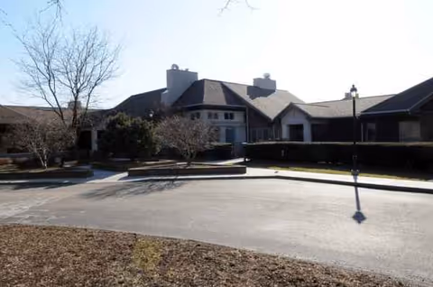 Exterior view of Concordia of Franklin Park building with driveway, trees, and lamppost