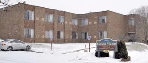 Exterior view of Edison Manor Nursing and Rehabilitation Center in a snowy parking lot.