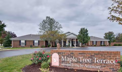 Exterior view of a single-story brick senior living facility with a Maple Tree Terrace sign.