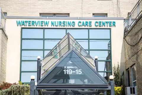 Front view of Waterview Nursing Care Center entrance with glass facade and triangular awning.