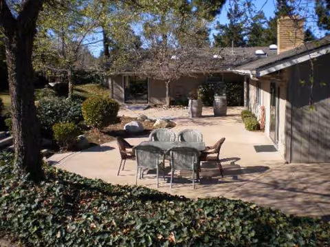 Outdoor courtyard with a table and chairs in front of a residential building.