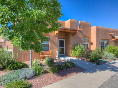 Exterior view of The Montecito of Santa Fe senior living facility with bench and desert landscaping.