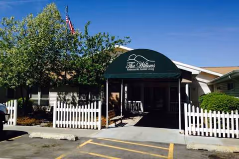 Exterior view of The Willows Retirement & Assisted Living entrance with a green awning.