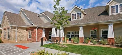 Exterior view of Brookdale Arvada building with lawn, planters, and seating.