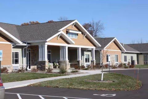 Exterior view of a single-story memory care facility with a covered entry.