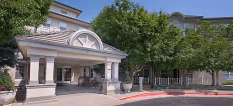 Exterior view of Belleview Suites at DTC entrance with columns and trees.
