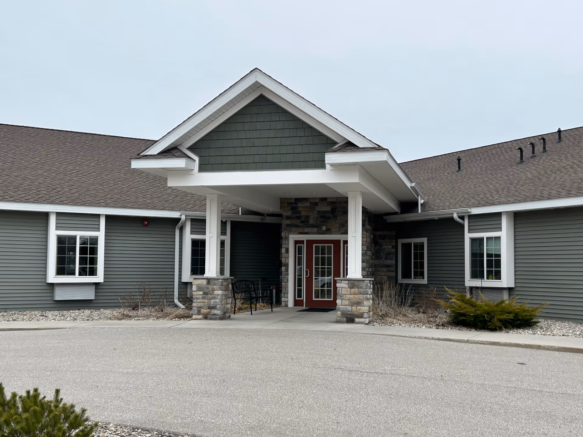 The entrance of Coleman Fields Assisted Living & Memory Care facility featuring a covered porch and stone accents.