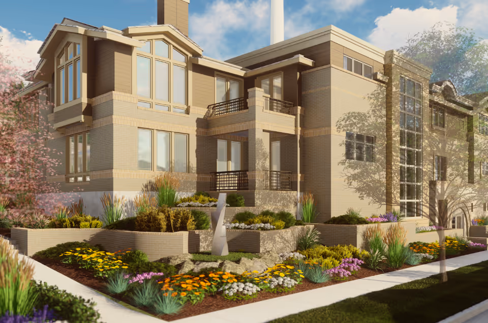 Exterior view of a multi-story brick senior living building with balconies and tiered landscaped flower beds.