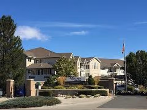 Front view of Sierra Place Retirement Community building with sign and landscaped entrance.