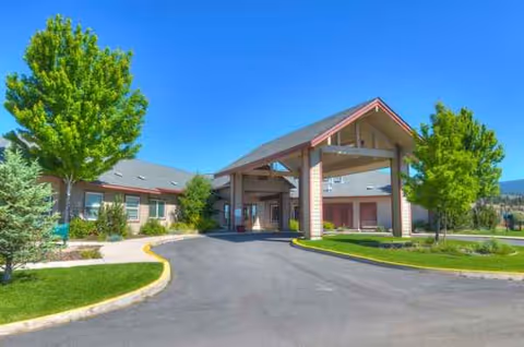 Sunny exterior view of Eagle Lake Village senior living with porte-cochère entrance.